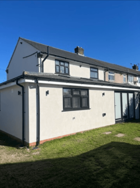 Finished single-storey rear extension with white render, viewed from the garden