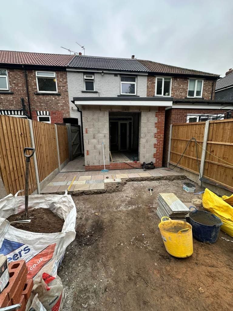 Blockwork shell of a rear extension mid-build, garden view